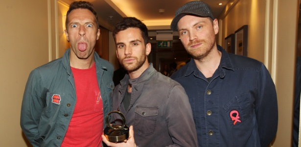 Chris Martin faz careta e Guy Berryman e Jonny Buckland, do Coldplay, seguram o troféu de melhor banda da atualidade no Q Awards