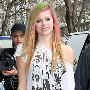 Com mechas verdes e rosas no cabelo, a cantora canadense Avril Lavigne atende fãs na saída de um hotel em Paris (8/2/2011) - Brainpix