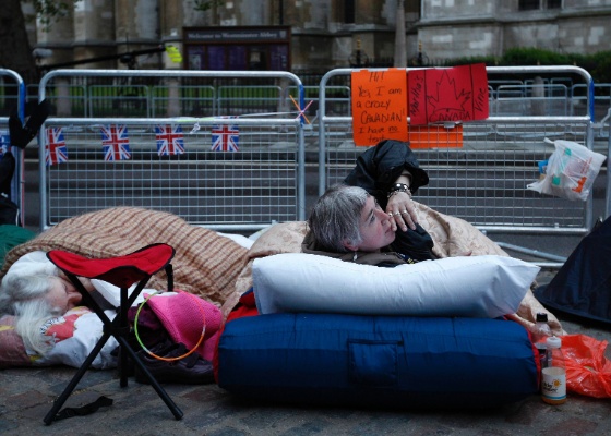 A canadense Sheree Zielke (dir.), de 55 anos, acampa sem barraca em frente à Abadia de Westminster para assistir ao casamento real (28/4/2011)