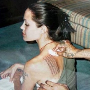 Angelina tatua uma prece budista simbolizando seu filho Maddox, em Bancoc, na Tailândia. Essa tattoo cobriu o símbolo japonês da morte (23/04/2003)
