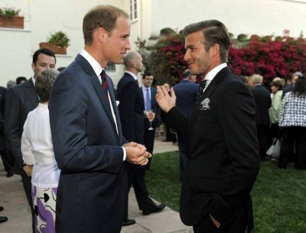 Príncipe William (à esq.) conversa com o jogador David Beckham durante recepção preparada para o casal real no consulado britânico em Los Angeles. A mulher de Beckham, Victoria, grávida de nove meses, não foi ao evento (8/7/11) 