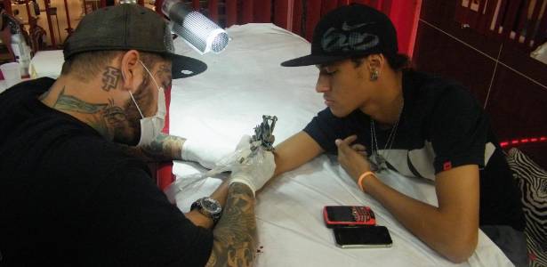O tatuador Adão Rosa tatua o jogador do Santos, Neymar (30/8/11)