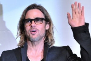 De cabelo grande e óculos, Brad Pitt cumprimenta fãs e fala com o público na estreia de "Moneyball" em Tóquio, no Japão (9/11/11) - AFP