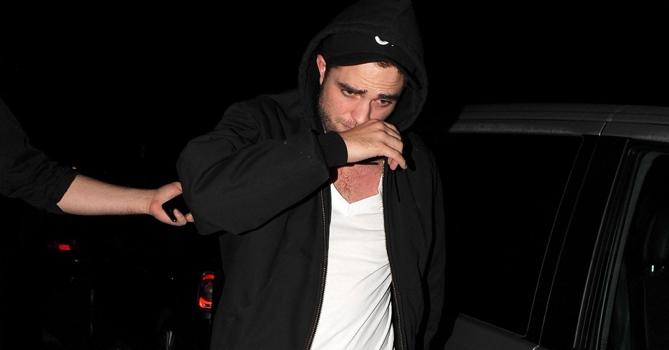 Robert Pattinson deixa bar de Camden Town, onde tomou umas cervejas com a namorada, a atriz Kristen Stewart, acompanhado de segurança (23/11/11).