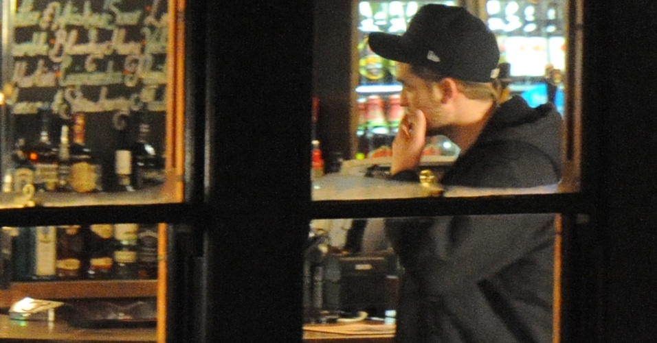 Robert Pattinson se diverte tomando umas e outras ao lado de amigos e da namorada, Kristen Stewart, num bar de Camden Town, bairro de Londres (23/11/11).
