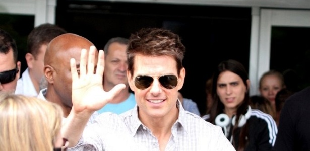Tom Cruise acena para fãs ao desembarcar no aeroporto do Galeão, no Rio de Janeiro (14/12/2011) - AgNews