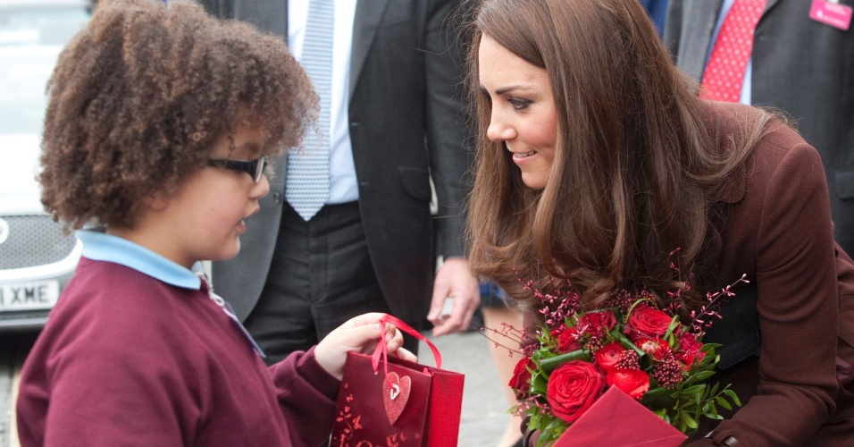 Kate Middleton recebe flores e presente do garoto Jaqson Johnston-Lynch, de oito anos, antes de visitar um bar para alcóolatras reabilitados em Liverpool (14/2/12) 