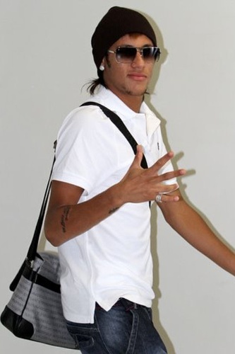 Neymar desembarca no aeroporto Santos Dumont, no Rio de Janeiro, e acena para os fotógrafos. O jogador estava de touca (18/1/12)