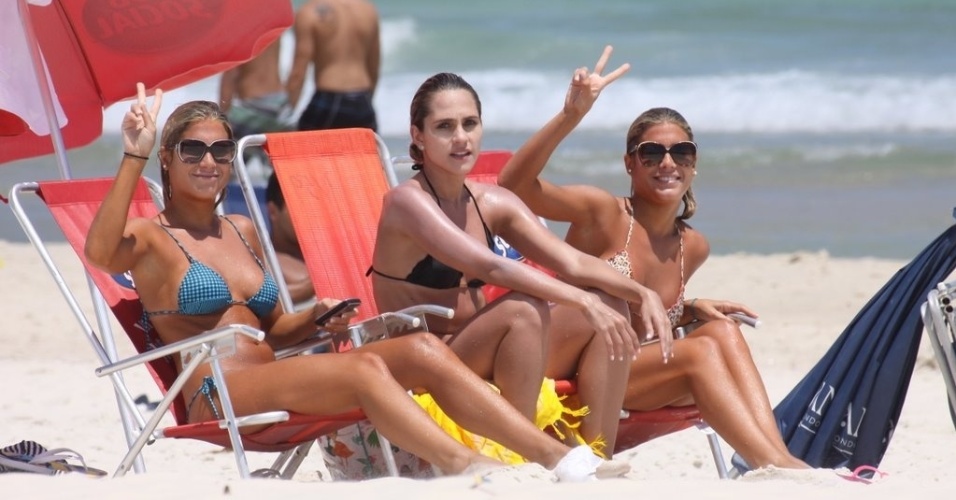 Ao lado de uma amiga, as gêmeas Bia e Branca Feres acenam para o paparazzo na praia da Barra, na zona oeste carioca (2/2/12)