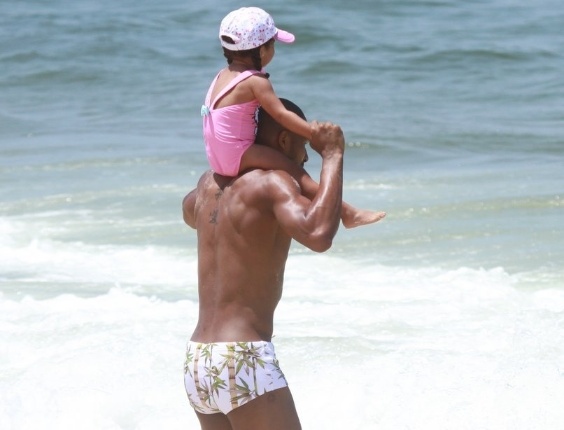 Leandrinho brinca com a filha, Alícia, na praia da Reserva, no Rio de Janeiro (24/2/12)