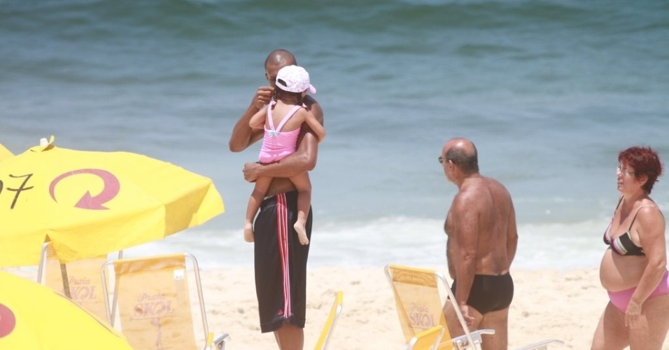 O jogador Leandrinho, marido de Samara, brinca com a filha, Alícia, na Praia da Reserva (24/2/12)