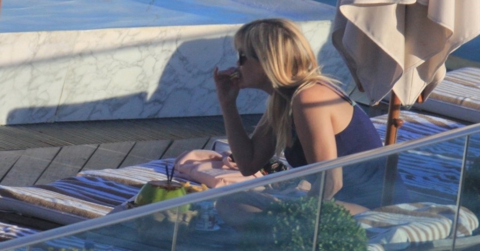 A atriz Reese Witherspoon faz um lanchinho durante banho de sol em piscina de hotel, no Rio de Janeiro (9/3/12)