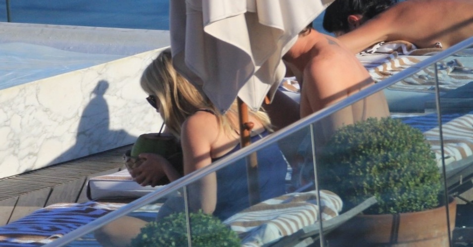 A atriz Reese Witherspoon refresca-se com água de coco durante banho de sol em piscina de hotel, no Rio de Janeiro (9/3/12)