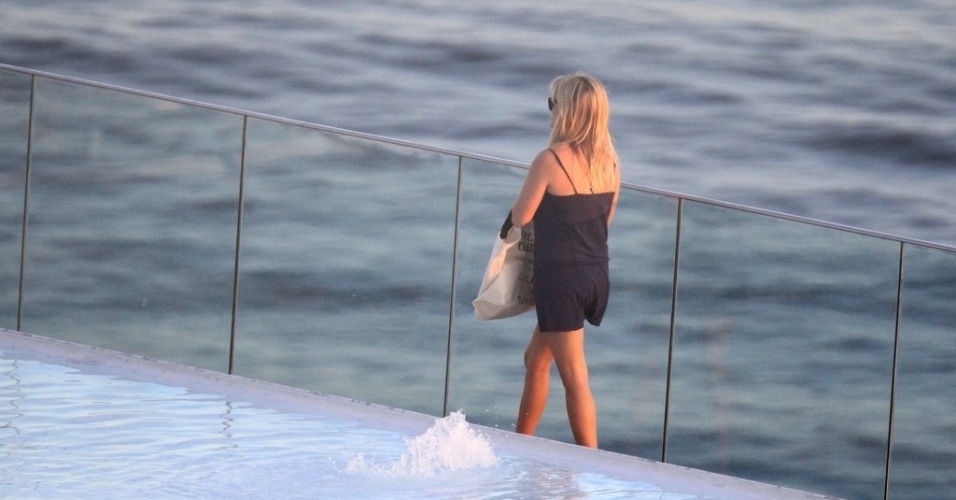 A atriz Reese Witherspoon refresca-se com água de coco durante banho de sol em piscina de hotel, no Rio de Janeiro (9/3/12)