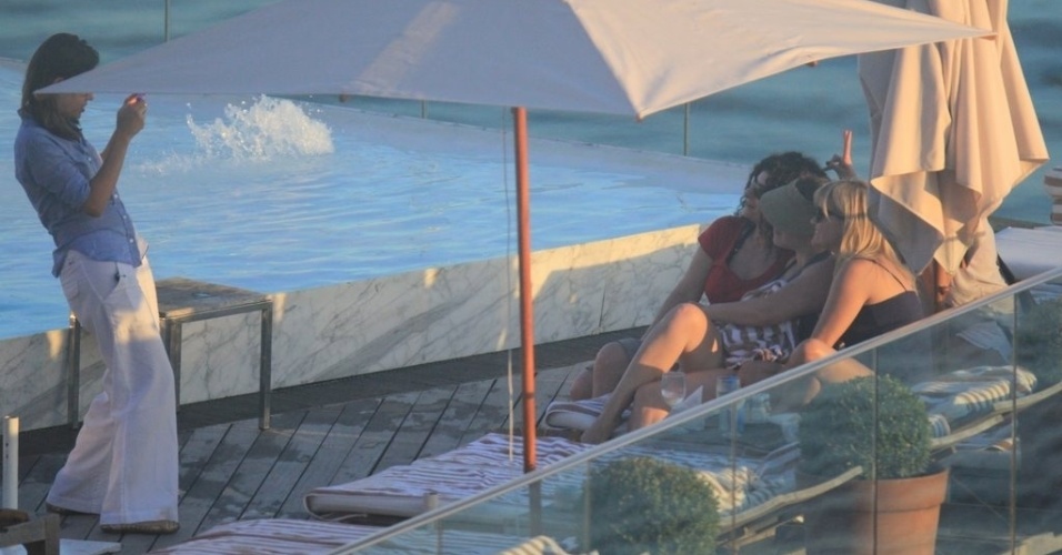 A atriz Reese Witherspoon tira fotos durante banho de sol em piscina de hotel, no Rio de Janeiro (9/3/12)