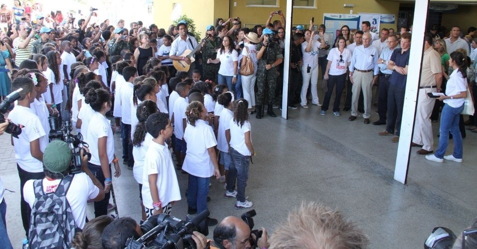 O príncipe Harry chega ao Complexo do Alemão, onde é recebido por um coral formado por crianças da comunidade, no Rio de janeiro (10/3/12)