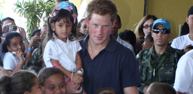 Príncipe Harry posa para fotos com crianças no Complexo do Alemão, no Rio de Janeiro (10/3/12)
