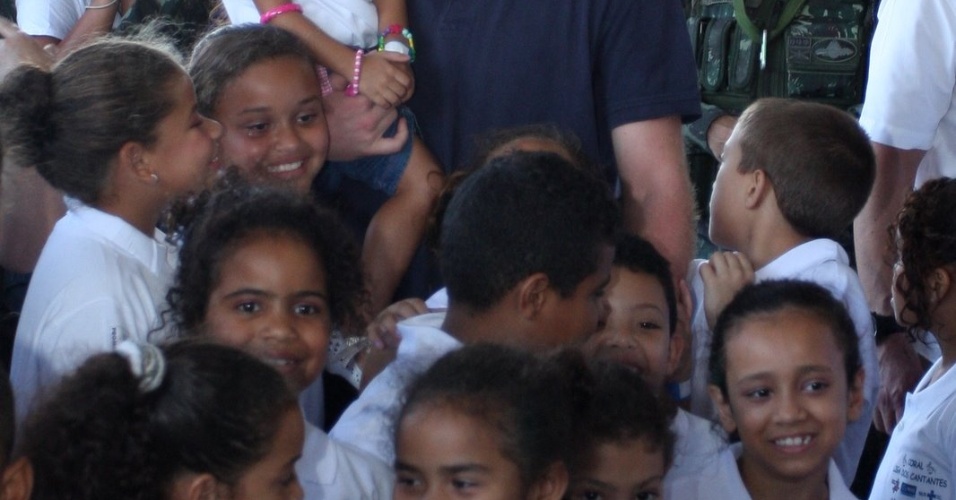 Príncipe Harry posa para fotos com crianças no Complexo do Alemão, no Rio de Janeiro (10/3/12)