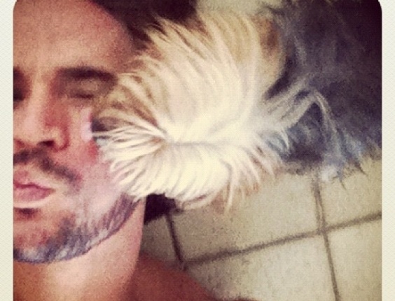 Ex-BBB Rodrigo posta foto em que leva lambida de seu cachorro (13/3/12)