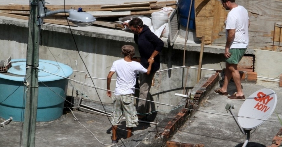 O ator francês Vincent Cassel recebe o apoio de um morador durante visita à comunidade do Vidigal, na zona sul do Rio (15/3/12)