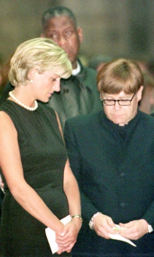 Ao lado da princesa Diana, o cantor volta a escolher um modelo discreto e quadrado de óculos em missa póstuma em homenagem ao estilista Gianni Versace (22/7/97)