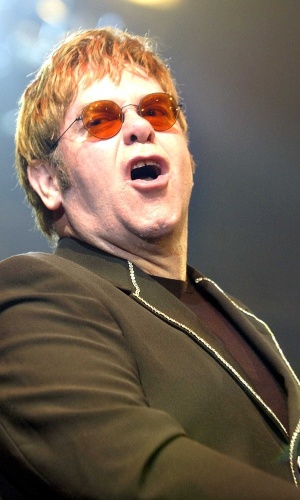 O cantor Elton John usa óculos laranja em show beneficente na cidade de Erfurt, Alemanha (16/6/02)