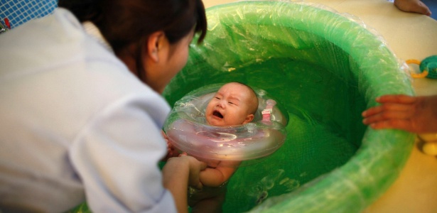 Em maternidade chinesa, cuidadora conduz bebê em exercício na água - Reuters