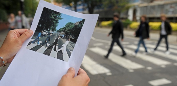 Imagem impressa da famosa foto dos Beatles em Abbey Road é mostrada na rua da Londres onde fãs imitam a cena (07/08/2009)