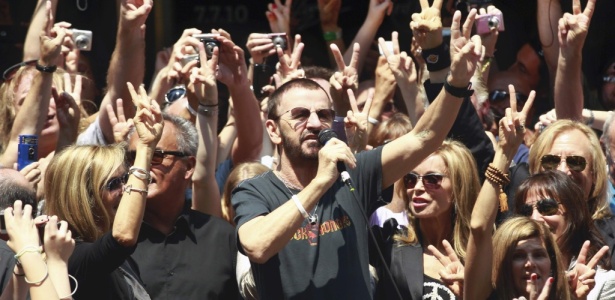 Ringo Starr (com microfone) faz o sinal de "paz e amor" em Nova York no dia de seu aniversário de 70 anos (07/07/2010) - REUTERS/Brendan McDermid