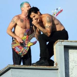 O baixista Flea e o vocalista Anthony Kiedis do Red Hot Chili Peppers gravam o clipe de "The Adventures of Rain Dance Maggie" no telhado de um prédio em Venice Beach, Los Angeles (30/7/11) - Brainpix