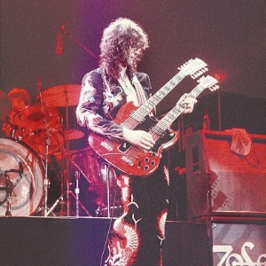 O guitarrista Jimmy Page é fotografado com roupa de dragão e guitarra de dois braços em show da banda Led Zeppelin, em 1975 - Divulgação